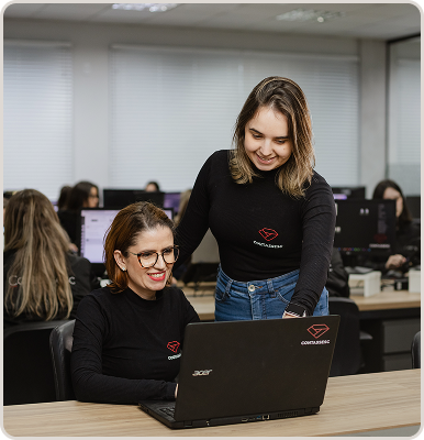 Especialista da Contassesc auxiliando uma colega no computador